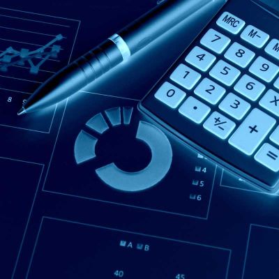 Calculator and pen sitting ontop of graphs and reports