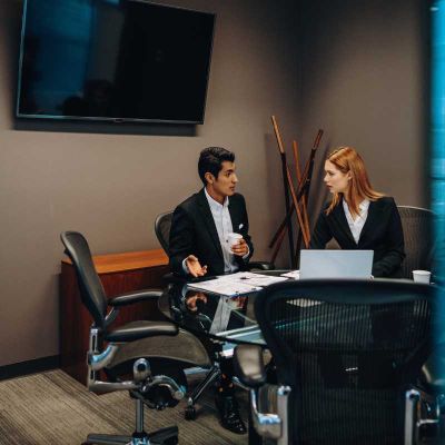 Employees sitting in conference room talking