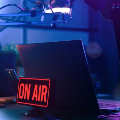 TV broadcasting on air sign in front of laptop on desk